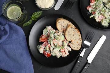 Delicious salad with mayonnaise served on black table, flat lay