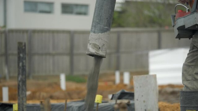 CLOSE UP Cement Pump Hose Pours Out Concrete Onto Property Slab
