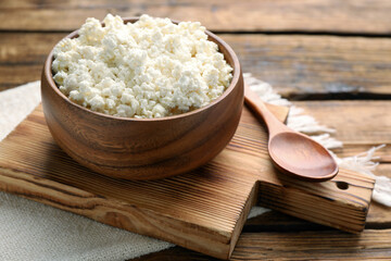 Delicious fresh cottage cheese on wooden table, closeup