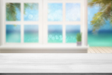Blank white wood table top and window with blurry sea view and palm leaves background Product Display stand