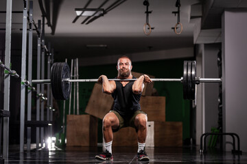Fototapeta na wymiar Muscular athlete lifting very heavy barbell