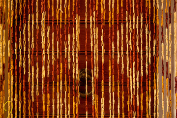 Wooden door with a curtain of woven ropes in wicker