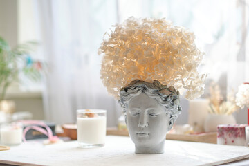 human bust with a potted plant as a spikey hairstyle of Dried Hydrangea flowers