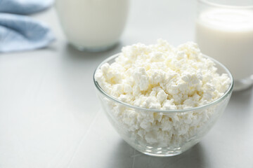 Delicious fresh cottage cheese in bowl on grey table