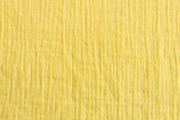 Soft muslin fabrics, baby blanket background. Cotton clothing and textiles. Natural organic fabrics texture. Light yellow, , lemon color. Close up. Top view - obrazy, fototapety, plakaty