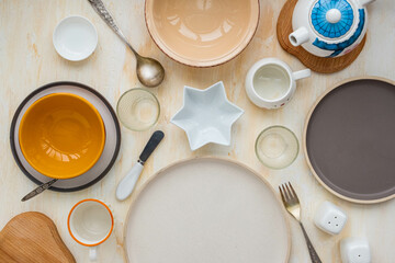 Table setting, empty dishes for serving family breakfast on a light concrete background.