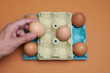 Eggs in an egg carton with orange background