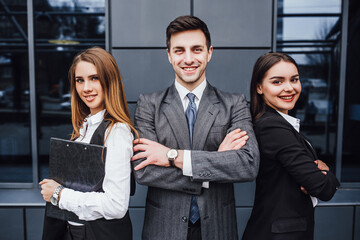 Portrait of three young smiling lawyers standing crossed arms!
