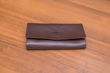Brown leather wallet on the wooden table