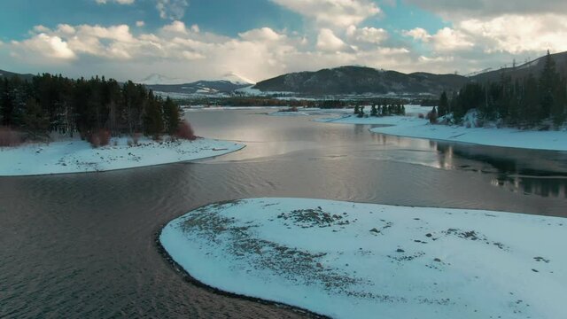Aerial: Islands, forest and mountains covered in snow in Dillon Reservoir. Frisco, Colorado, USA