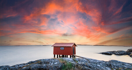 a colorful sunset of a red little fisherman's hut at the coast of sweden. Longe exposure