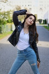 Hübsche junge Frau mit Lederjacke und Jeans