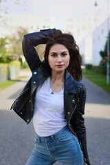 Fototapeta premium Hübsche junge Frau mit Lederjacke und Jeans