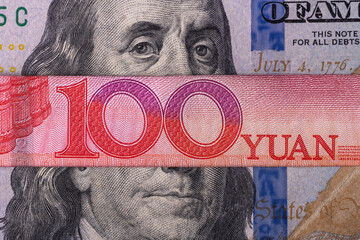 Overlapping fragmentary 100 Chinese yuan and 100 US dollar bills