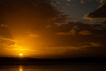 Beautiful sunset on the lake. The sun reflects its light on the water.