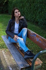 Hübsche junge Frau mit Lederjacke und Jeans