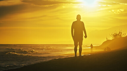 Backlit people at the beach on a windy day