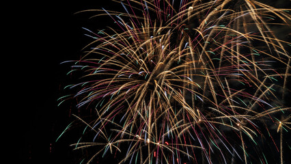 Beautiful colorful holiday fireworks on the black sky background, long exposure. Festive concept.