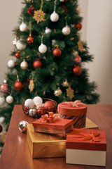 Merry Christmas and Happy New year Holidays! Decorating the Christmas tree indoors. Macro or close picture of xmas tree and gifts