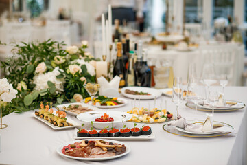 Wedding Setup . Wedding decor. Banquet. The chairs and round table for guests, served with cutlery, flowers and crockery