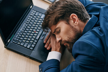 business man sleeping in front of laptop at his desk office