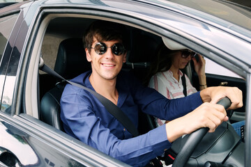 Smiling Young Caucasian traveler couple love is relaxing and Driving a car for travel on holiday. Happiness of Honeymoon trip on vacation concept