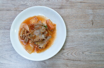 fried pork bone with slice carrot and onion with sweet and sour sauce on plate
