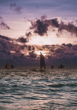 Scenic photo of sailboats in the ocean on the sunset. Picturesque picture of two sailing ships in the sea. Amazing sunset in the ocean