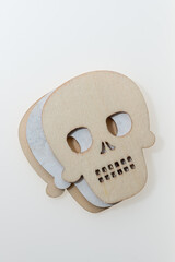 close up of 2d or flat wooden cut outs of skulls on white