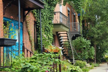 Street view of Montreal, Quebec, in Canada. Plateau Mont Royal neighborhood, one of the most beautiful in the city with colorful houses and greenery.
