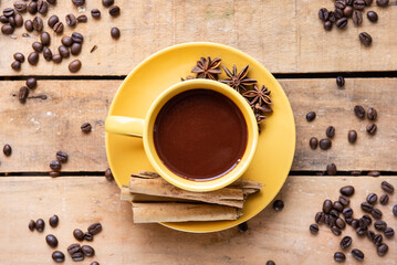 Top view of coffee cup with coffee beans on wooden table