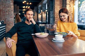 young couple sitting in a restaurant chatting dating