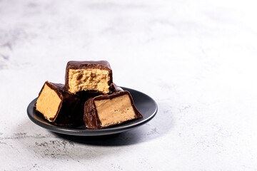 khalva sweets candy cubes with chocolate on light background with copyspace