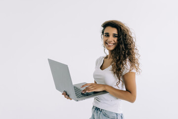 Young woman standing with laptop on white background. Looking camera.