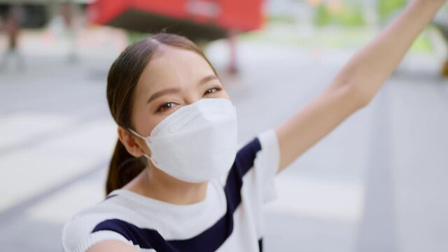 young smiling asian female adult video call selfie with cheerful move around to show the famous place of vacation weekend to her family by smartphone devide happiness travel concept