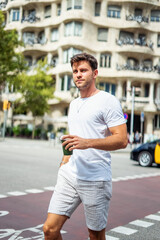 Trendy guy with takeaway drink on street