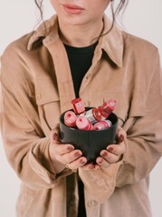 The girl holds in her hand jars of dyes for permanent makeup close-up