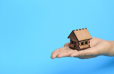 Businessman's hand placed house. Blue background. Real estate concept. Mortgages. Leasing. Save money for future and retirement.