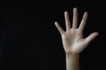 Fototapeta premium Woman's palm on black background. Abused woman. Stop violence and abuse of women. International Women's Day.