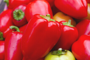 Red bell pepper on the counter in the supermarket. A lot of peppers in a heap. Natural background