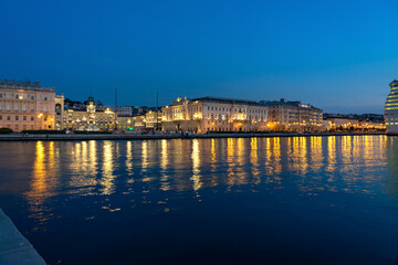 Fototapeta premium sea coast in Trieste Italy with beautiful illuminated buildings and reflection on the water