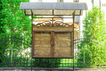 Church wooden empty notice board on  street. Parish council outdoors memo board behind glass