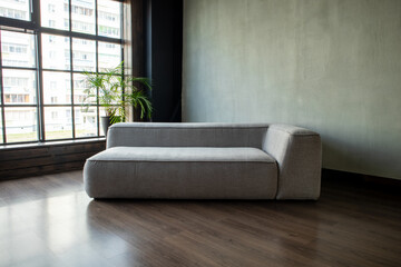 soft upholstered light sofa with modules in the interior with a panoramic window