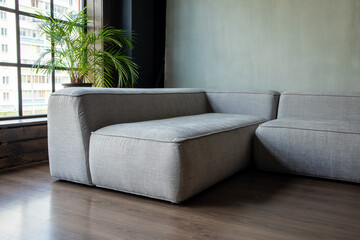 soft upholstered light sofa with modules in the interior with a panoramic window