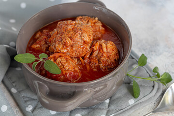 Meat balls on a light background with sage and parsley leaves. Homemade lunch.