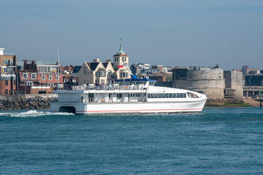 Portsmouth, England, UK. 2021. A passenger catamaran ferry outbound from Portsmouth Harbour  passing the Round Tower fortification.