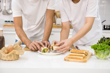 lgbt gay's hands make sandwich on kitchen table