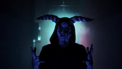 Demon with horns conjuring close-up. Silhouette of devil in darkness. Halloween, a traditional American holiday concept. Evil magician making rite or sacrifice during full moon, evil spirit, satan.