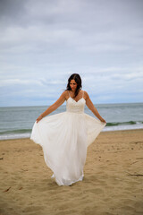 Fototapeta na wymiar Junge schöne Braut im Hochzeitskleid am Meer