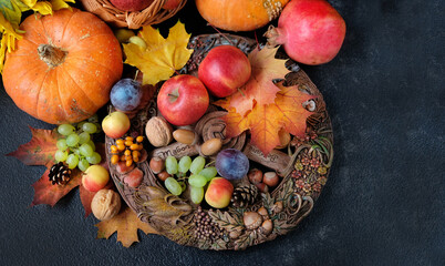 Wiccan altar for Mabon sabbat. Seasonal fruits, pumpkins, flowers, nuts, wheel of the year on black background. pagan, Wiccan traditions. Witchcraft, esoteric spiritual ritual. flat lay - obrazy, fototapety, plakaty